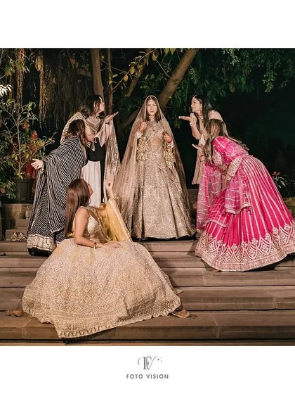 The bride and her bridesmaids sharing a fun, loving moment, blowing kisses to their friend on her special day.