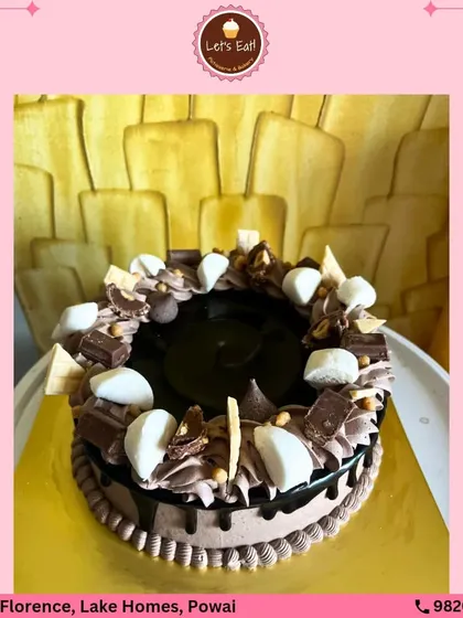An ultimate chocolate lover's dream cake. This creation is loaded with marshmallows, chocolate chunks, and a rich chocolate drip, offering a variety of textures and intense chocolate flavor in every bite.