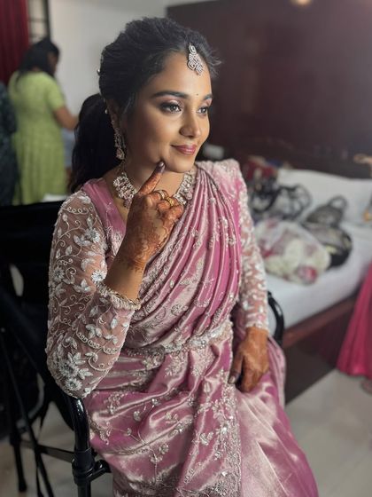 A candid moment with my beautiful bride Surya during her reception in Dindugal. Her glam makeup, featuring a smoky eye and nude lip, looks stunning with her embroidered pink velvet saree.