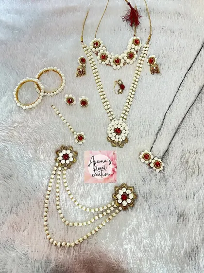 This halwa jewellery set is accented with red details and gold charms, offering a more ornate and traditional look for a new bride.