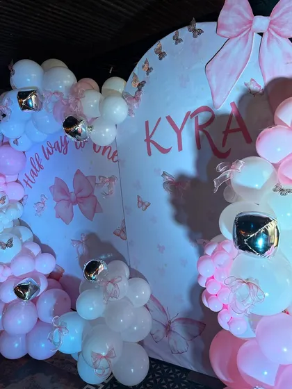 Another angle of the chic bow-themed decor, showing the custom 'Kyra' and 'Half way to one' lettering.
