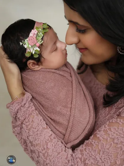 A tender close-up from a newborn photoshoot, capturing the delicate features of the baby and the mother's loving gaze. These quiet moments are so precious.