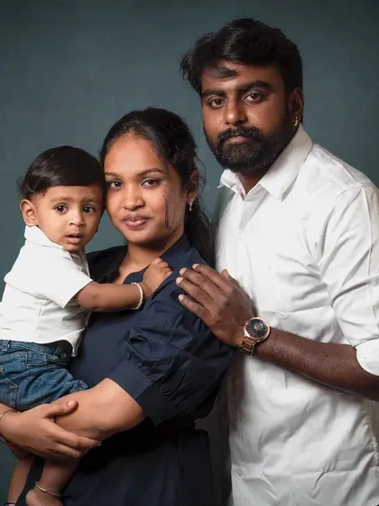 A strong and loving family portrait. The classic posing against a dark, textured backdrop gives this image a timeless, fine art quality.