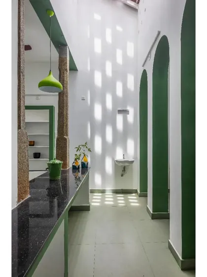 A corridor is animated by patterns of light filtering through perforated walls, turning a simple passage into a dynamic experience.