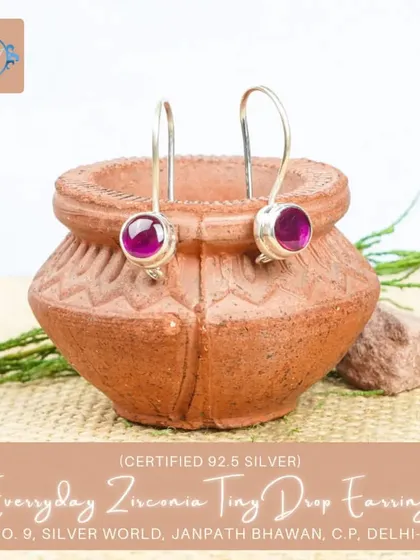 A pair of tiny drop earrings with a rich, ruby-colored zirconia stone. These add a touch of warmth and color to any outfit.