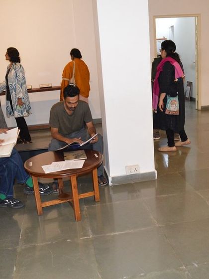 Visitors reading the exhibition materials and browsing the books.