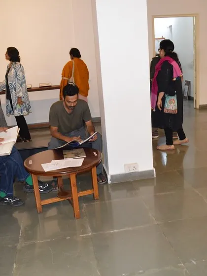 Visitors reading the accompanying texts and books at the 'Quieter than Silence' opening.