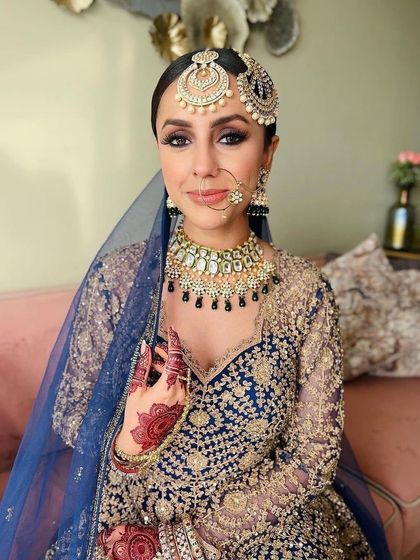 A portrait of a beautiful bride in a royal blue ensemble. Her makeup features a classic smokey eye and a neutral lip, creating a look of sophisticated elegance.