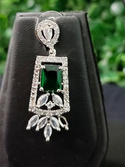 Another angle of the emerald-green AD earring, showcasing its sparkle.