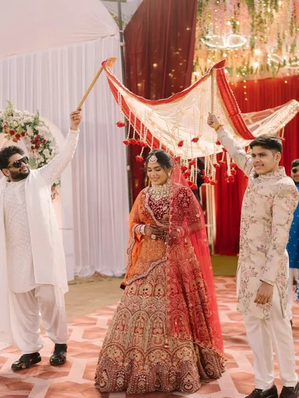 The bride's grand entrance under the phoolon ki chadar. Her radiant makeup ensures she is the center of attention as she walks towards her new beginning.