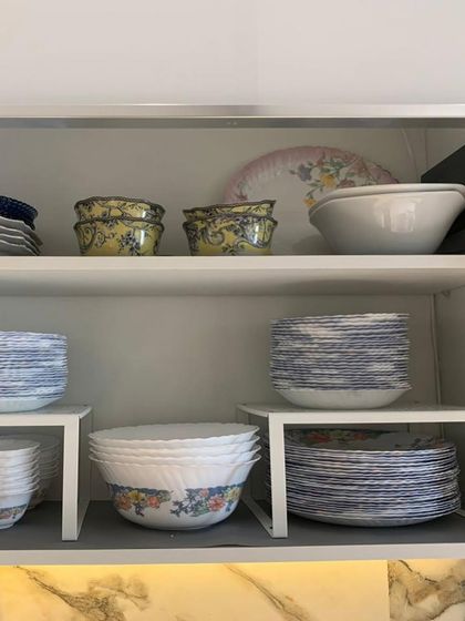 We used white risers to organize this collection of Corelle dinnerware. The risers help define the space and prevent stacks from becoming too high and unstable.