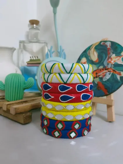 A stack of my handmade bangles, ready for Navratri or any festive occasion. I create these with colourful threads, mirror work, and painted details, and I can customise a set to perfectly match your outfit.
