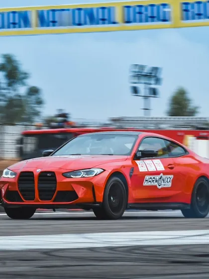 A red BMW M4 Competition captured in a motion blur, highlighting its incredible speed on the track. This is the kind of high-impact photography that defines our event coverage.