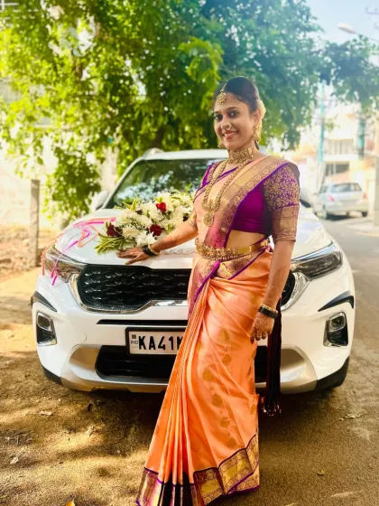A happy bride posing on her wedding day, adorned in a full set of my traditional temple jewellery. The long necklace and matching choker add elegance to her silk saree.