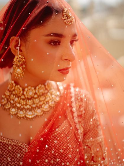 A close-up portrait of Shree on her wedding day. The look is perfected with a statement gold choker necklace and a matching maang tikka, highlighting her classic bridal beauty.