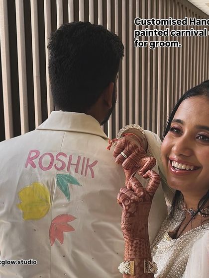 A happy client showing off the personalized detail on the groom's jacket. This small touch makes the piece uniquely his and a cherished memory from their wedding carnival.