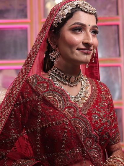 A happy moment captured. This bride's smile says it all. Her makeup is soft and radiant, enhancing her natural features and complementing her traditional red attire.
