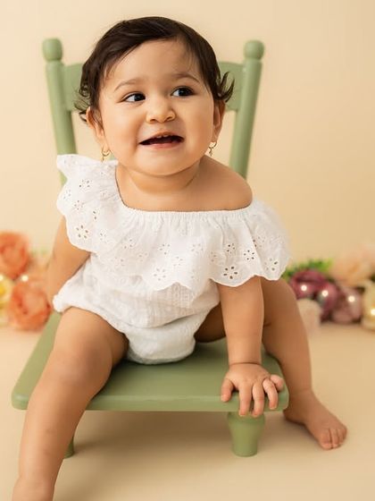 A bright, cheerful smile from her seat on the little green chair. This sitter session is full of personality and charm.