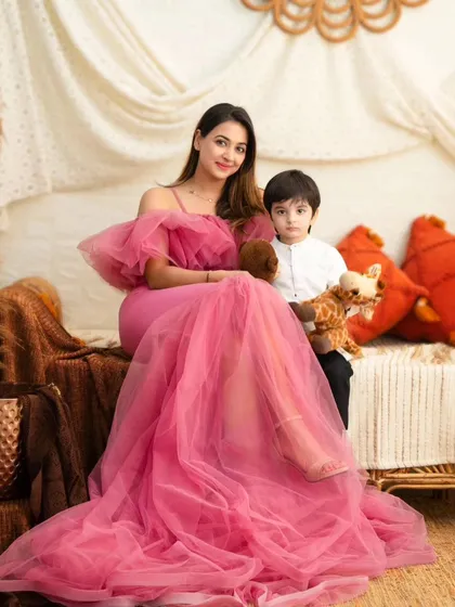 A mother and son moment. The mother's elegant pink gown shines in this portrait, complemented by the rustic charm of our autumn theme.