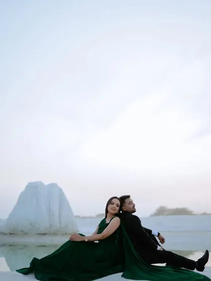 A wide shot that captures the vastness of the location and the intimacy of the couple's pose. It tells a story of two people alone together in a beautiful, secluded world.