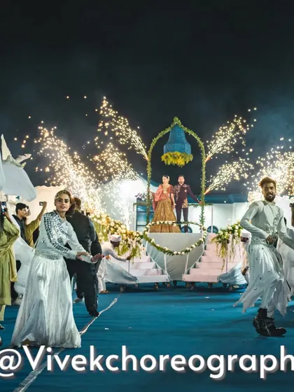 The full view of a dreamy varmala entry. The moving stage, dancers, and cold pyros all come together to create a stunning spectacle for the couple and their guests.