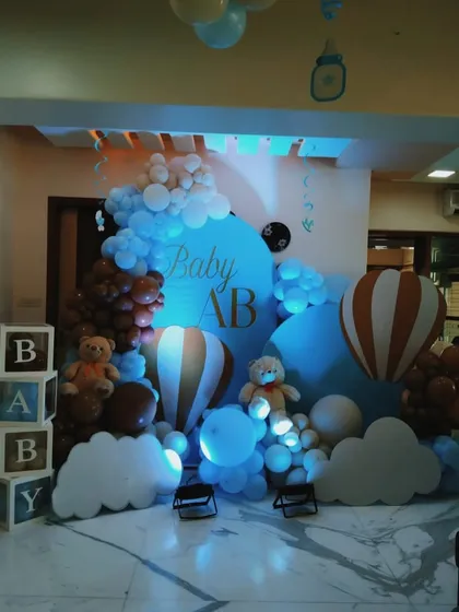 A dreamy "Baby AB" welcome party with a hot air balloon and clouds theme. The blue and brown color palette is perfect for celebrating a baby boy.