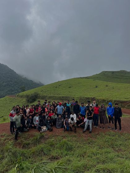 A large group photo on the green slopes of Kodachadri.