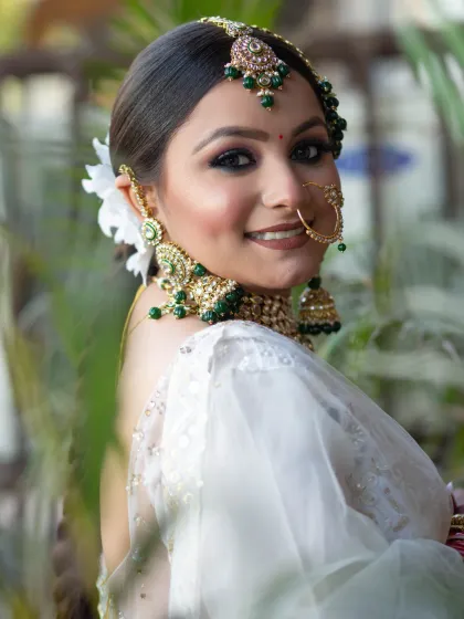 An elegant and fresh look for a bride in a white saree. I used a green smokey eye to match her jewelry and kept the rest of the makeup luminous and natural.