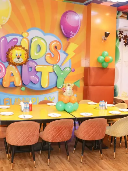 A decorated table in our party zone, featuring a "Kids Party" sign and animal-themed balloons. The space is bright, clean, and ready for fun.