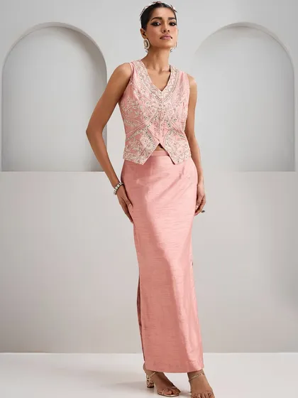 This embroidered pink co-ord set features a tailored vest and a sleek skirt. It’s a modern take on traditional wear that transitions seamlessly from a ceremony to an after-party.
