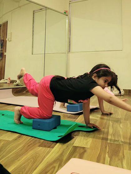 Using a yoga block for support in this balancing pose helps this young student build stability and confidence. Props are fantastic tools for making yoga accessible and safe for children.