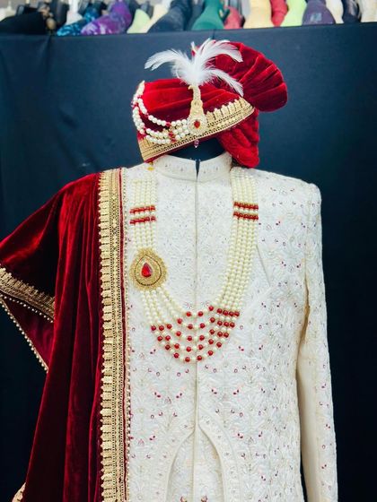 The complete groom's look is about harmony. This photo shows how the red accents in the handcrafted sherwani are picked up in the pearl necklace and the velvet of the custom turban.