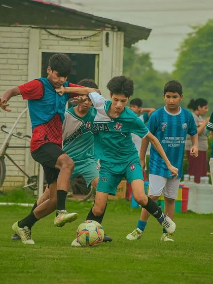 An intense battle for the ball involving three players, highlighting the competitive nature of the Pride Cup.