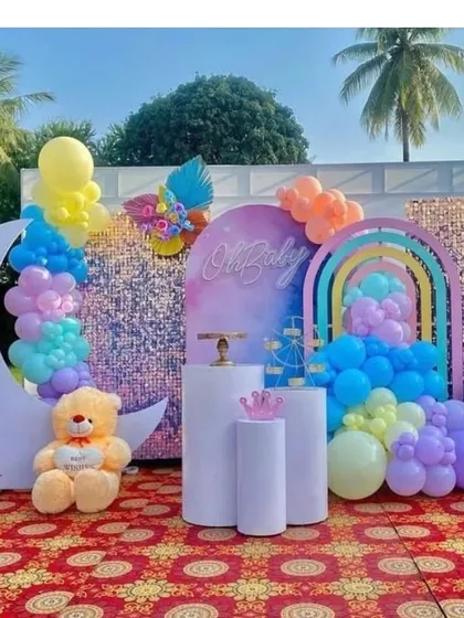 A dreamy 'Oh Baby' theme with a touch of sparkle. This outdoor setup includes a moon cutout, a shimmer wall backdrop, and a rainbow of pastel balloons, creating a magical photo corner for the parents-to-be.