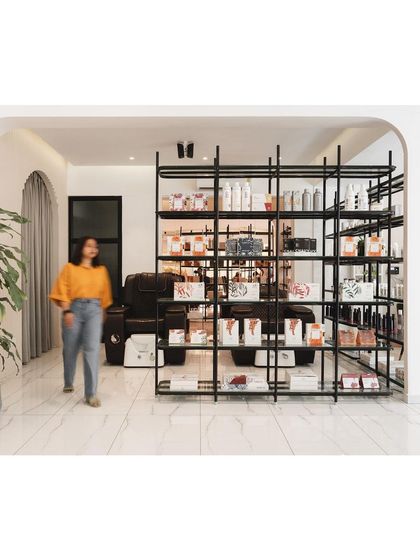 A repeat of the shelving unit, which acts as a functional and aesthetic centerpiece in the salon's layout.