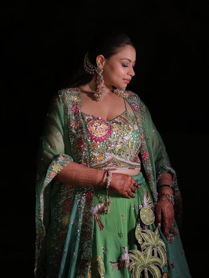 A stunning final shot of the client from the Qawwali night. Her half-up hairstyle with a jeweled accessory looks absolutely regal against the dark background.