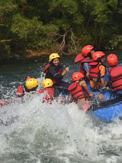 An instructor and campers work together as their raft tilts in the churning white water, a moment of pure action and teamwork.