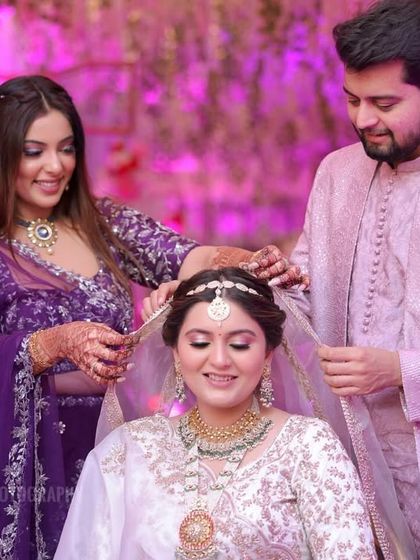 Siblings help the bride with her veil, a beautiful moment of support and love captured during the getting-ready process.