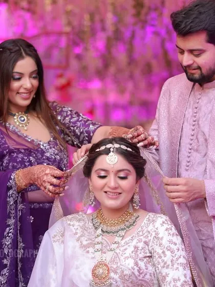 Siblings help the bride with her veil, a beautiful moment of support and love captured during the getting-ready process.