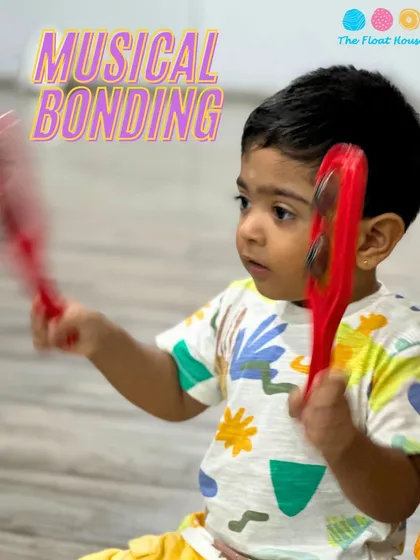 A toddler enjoying a musical bonding session. We host workshops designed for even our youngest guests to explore rhythm and sound.