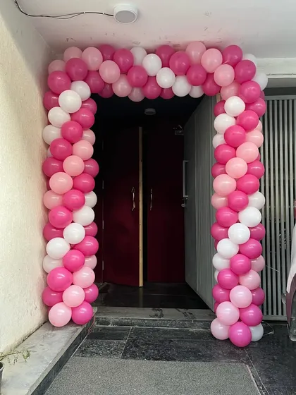The entrance to the party, decorated with a pink and white balloon arch to welcome guests.