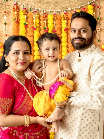 A beautiful family portrait celebrating Janmashtami. The family coordinates their outfits with the festive theme, creating a perfect, harmonious memory.