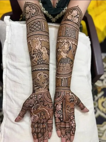 This full bridal mehandi includes figures from the wedding ceremony, along with portraits of Radha and Krishna, and the couple's names.