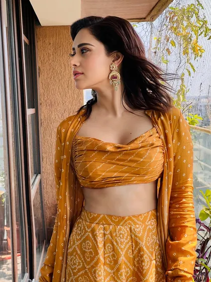 A vibrant bandhani print co-ord set for Nushrratt Bharuccha. This look, featuring a draped top and matching pants with a jacket, is perfect for a festive brunch or a casual wedding event.