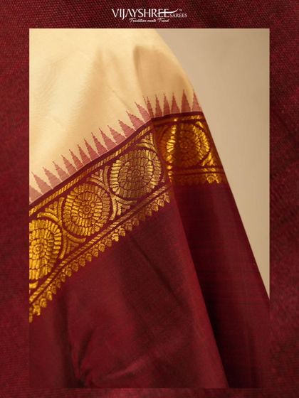 A close-up of a traditional border in cream and maroon, featuring circular motifs woven in pure gold zari.