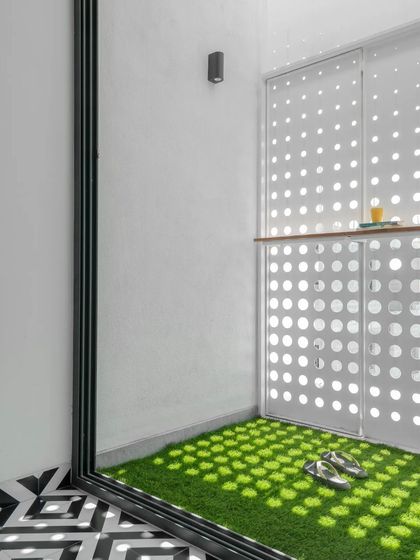 This small balcony space is transformed by the light filtering through the perforated screen. The design provides a private outdoor nook that feels connected to the outside world without being fully exposed.