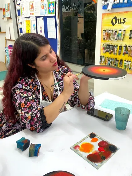 A participant adds the final touches to her galaxy-themed resin art. The process is engaging and allows for a lot of personal creativity.