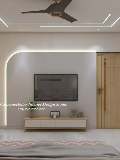 The TV wall in this bedroom is designed with a curved, backlit panel, creating a soft and modern look. The floating console keeps the floor space clear and adds to the airy feel.