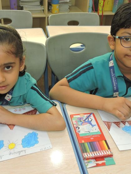 Two students collaborate on their drawings, sharing ideas and crayons during a creative classroom session.
