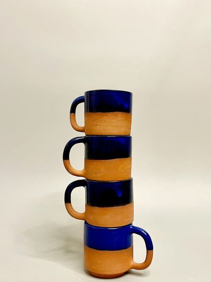 A stack of my cobalt blue and terracotta mugs. The stackable design is practical, while the handmade quality makes each one a unique piece of art.